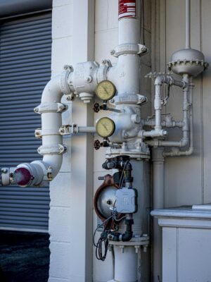 Close-up shot of an industrial pipe system featuring pressure gauges and valves outdoors.