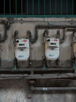 Four gas meters mounted on an exterior wall, showcasing urban utility infrastructure.