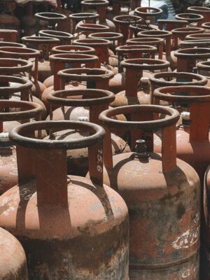 Rusty gas cylinders aligned outdoors in Nepal, showcasing industrial storage.