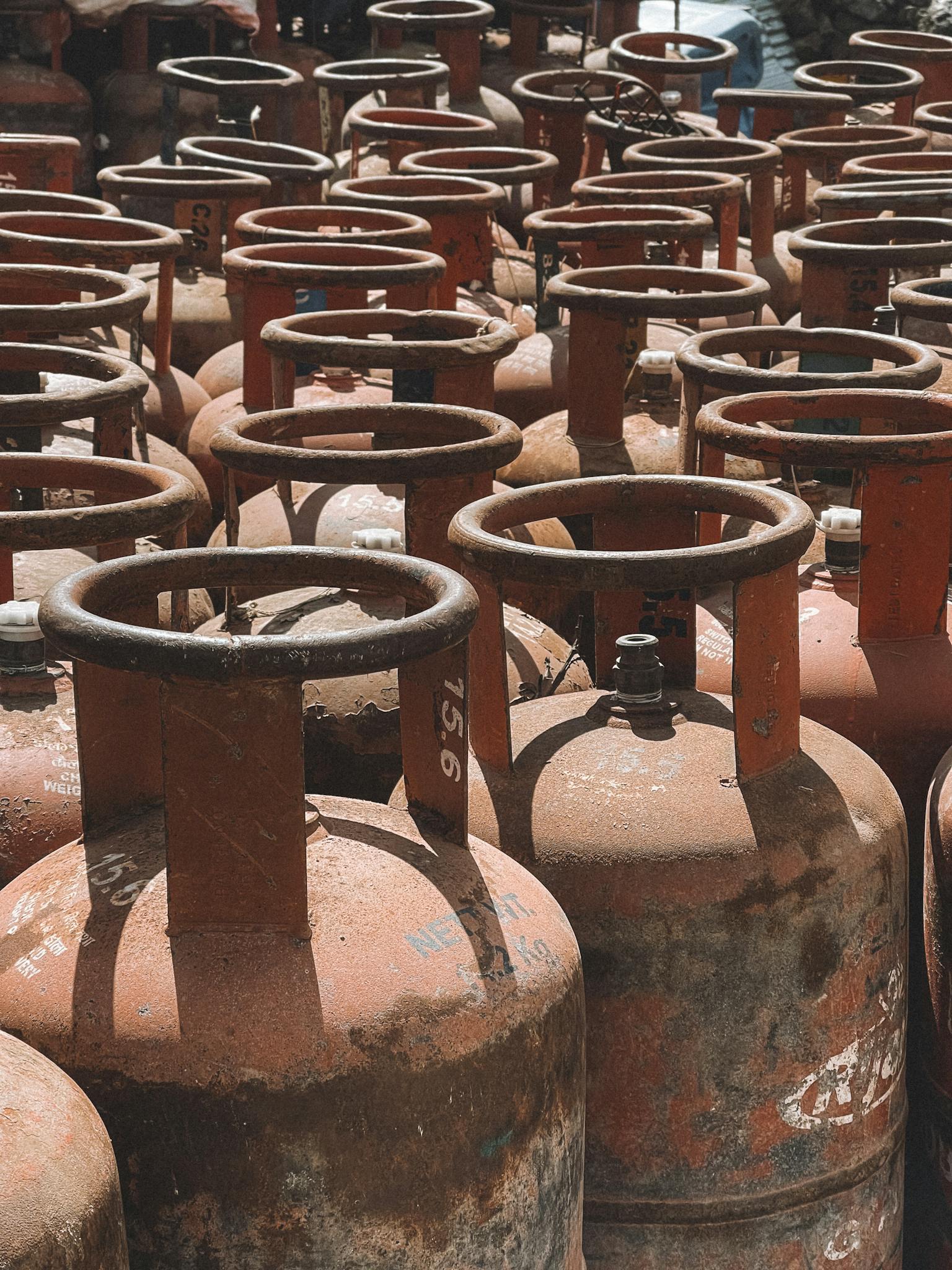 Rusty gas cylinders aligned outdoors in Nepal, showcasing industrial storage.