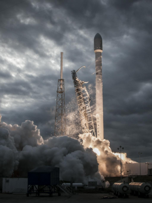 Smoke billows as a rocket launches into a dramatic evening sky, showcasing technological innovation.